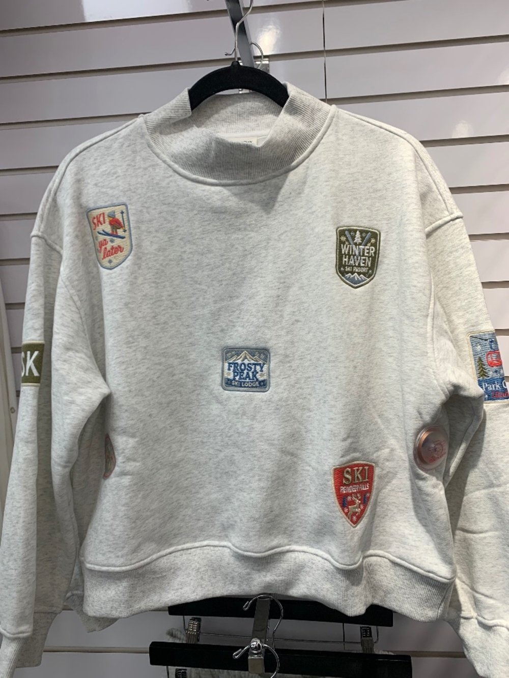 Sunday Edition gray sweatshirt with ski patches.